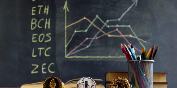 Kurse von Kryptowährungen auf einer Tafel hinter einem Schreibtisch mit Stiften und Krypto-Coins.